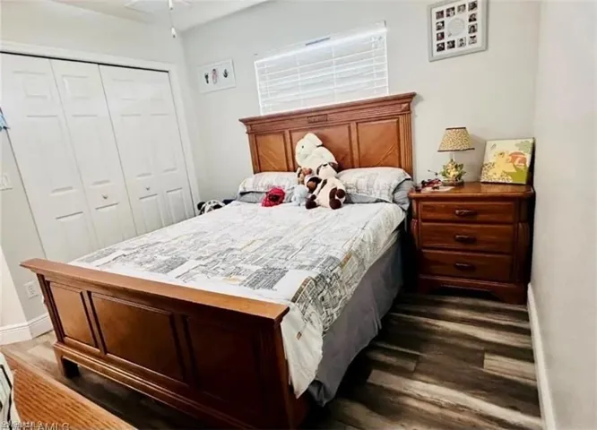 Bedroom featuring dark wood-style floors and a closet