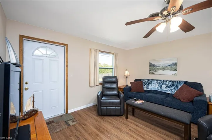 Living room featuring ceiling fan, baseboards, and wood finished floors
