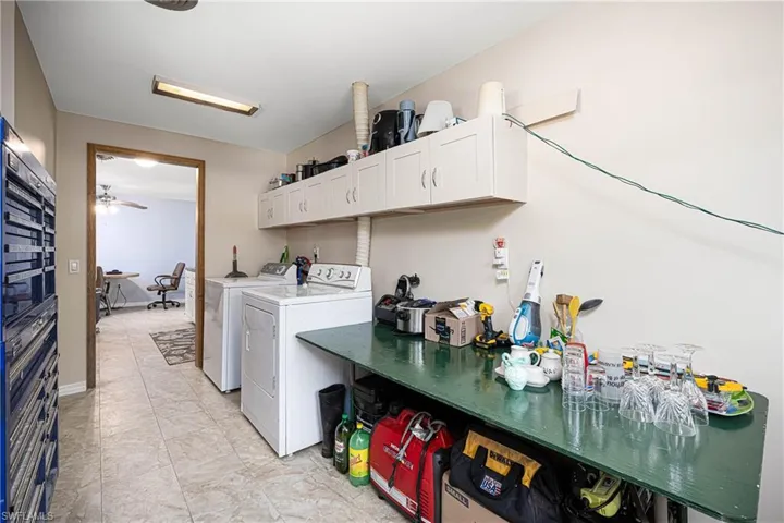 Laundry area featuring baseboards, cabinet space, and separate washer and dryer