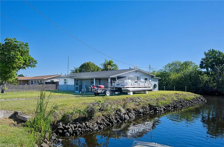 Rear view of property featuring a yard and fence