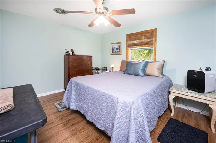 Bedroom with ceiling fan, baseboards, and wood finished floors