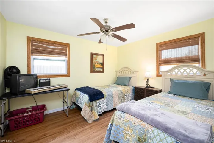 Bedroom with baseboards, wood finished floors, and a ceiling fan