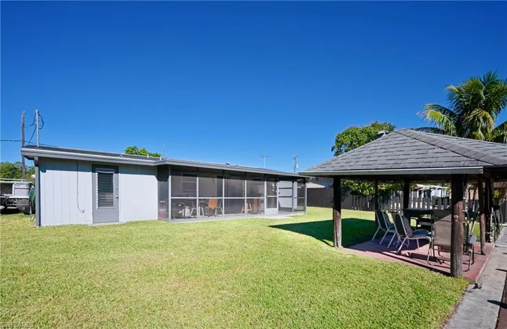 View of yard featuring a gazebo, fence, a sunroom, and a patio area