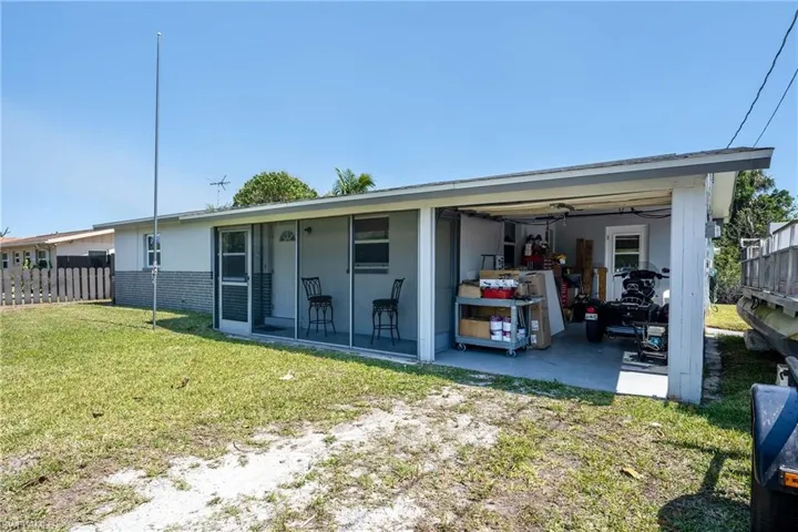 View of front of property featuring brick siding, a front lawn, and fence