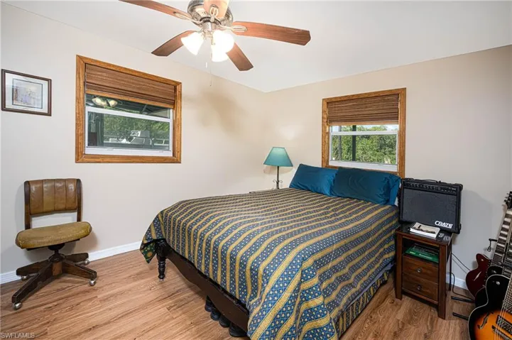 Bedroom featuring ceiling fan, baseboards, and wood finished floors