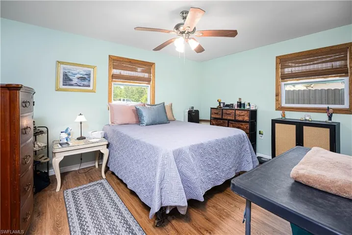 Bedroom featuring a ceiling fan, baseboards, and wood finished floors