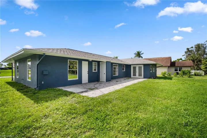 Rear view of property with a lawn