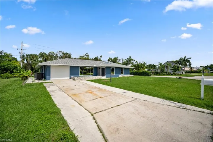 Ranch-style home with cooling unit and a front yard