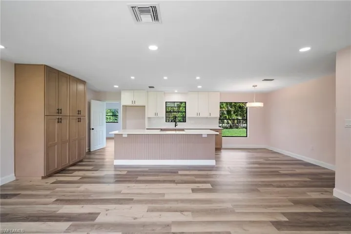 Kitchen with a center island, hanging light fixtures, and light wood-type flooring