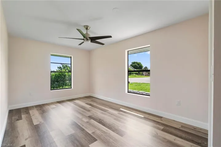 Unfurnished room featuring light wood-type flooring, a wealth of natural light, and ceiling fan