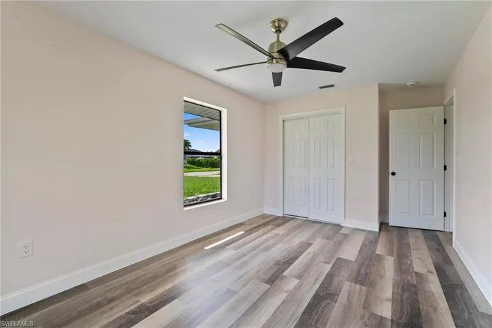 Unfurnished bedroom featuring a closet, wood-type flooring, and ceiling fan
