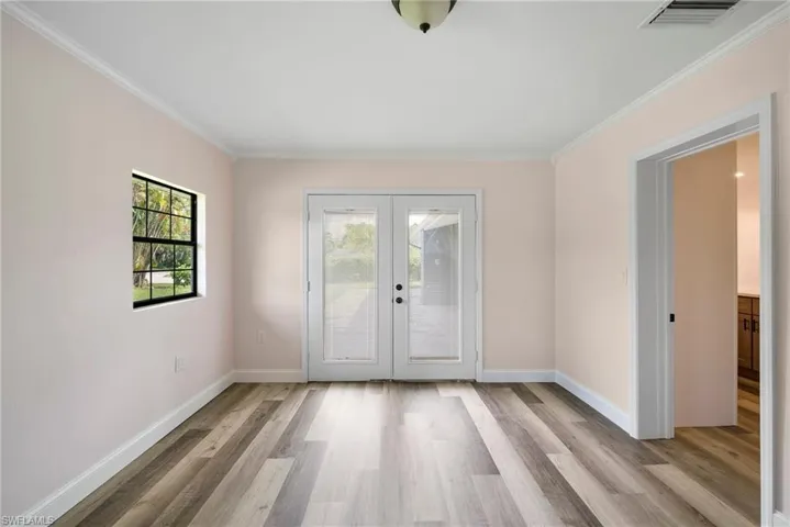 Doorway to outside featuring light hardwood / wood-style floors, french doors, and ornamental molding