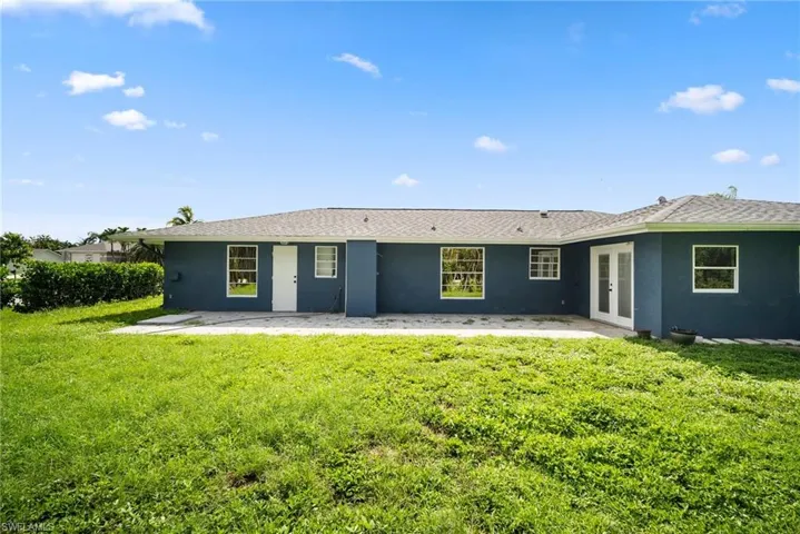 Back of house with a yard and a patio area