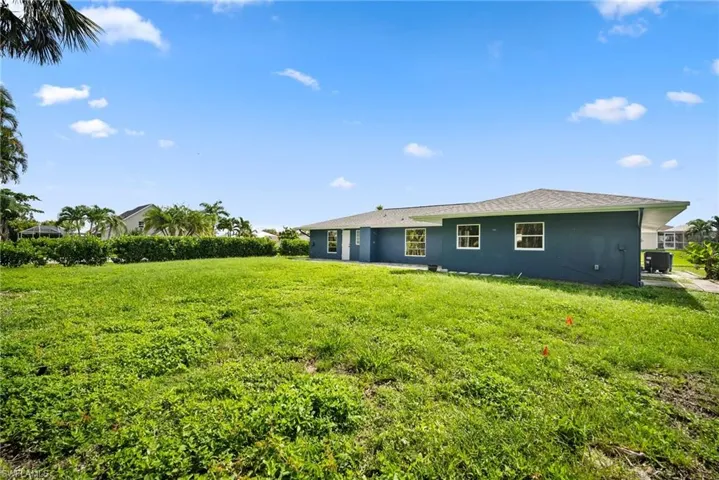 Back of property featuring a lawn