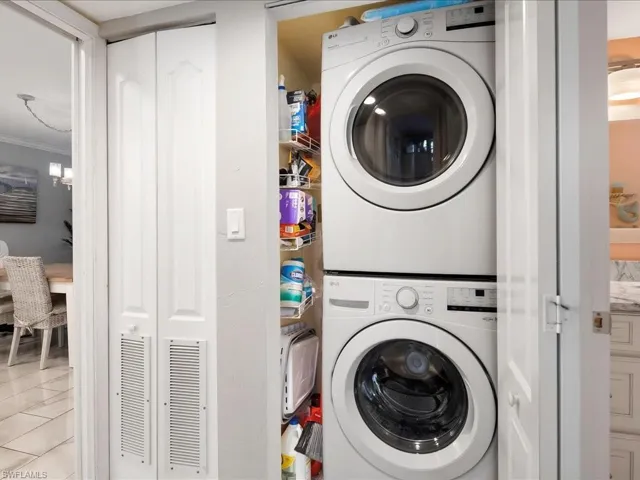 Washroom featuring stacked washer / dryer and tile patterned floors