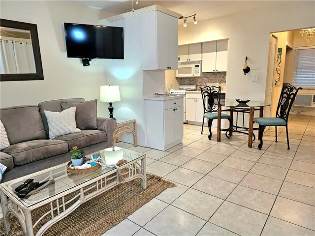 Living room with track lighting and light tile floors