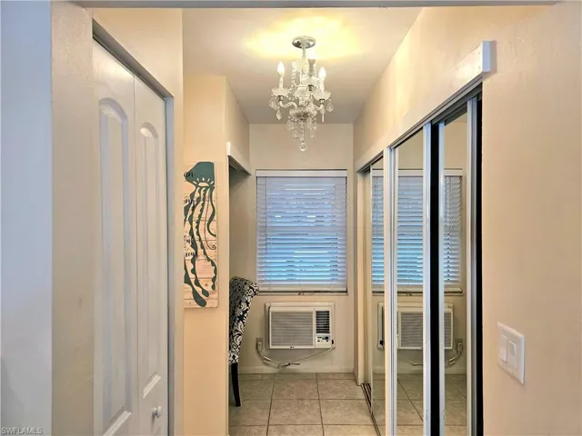 Hall with a notable chandelier and light tile floors