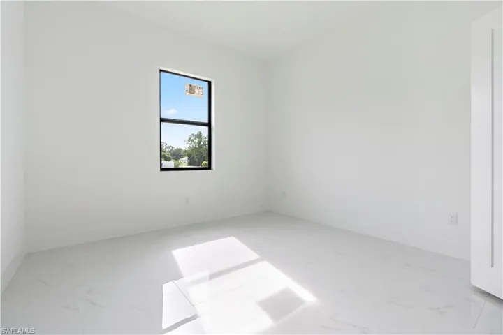 Spare room with light marble finish floors and baseboards