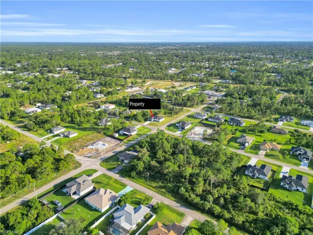 View of property location with nearby suburban area and a tree filled landscape
