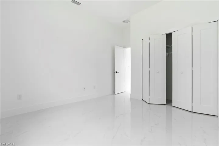 Unfurnished bedroom featuring a closet and light marble finish floors