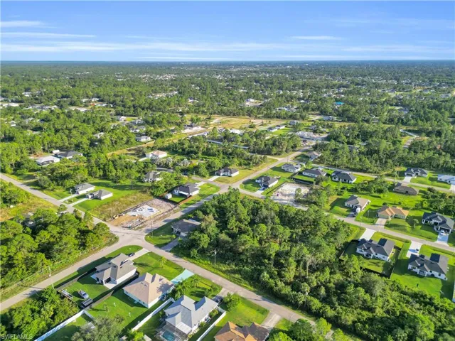 Aerial view of property and surrounding area featuring nearby suburban area