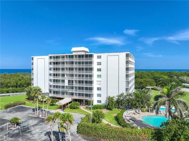 View of apartment building / complex with a water view and a community pool