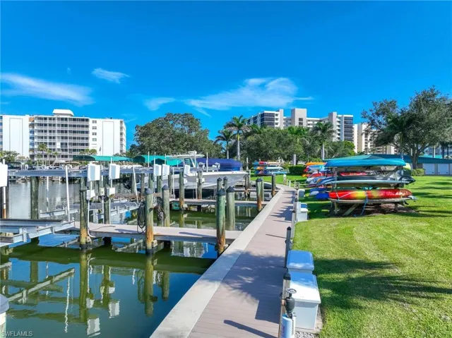 Dock area with boat lift, a yard, and a water view