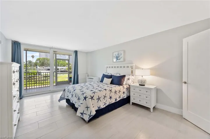 Bedroom featuring access to exterior and baseboards