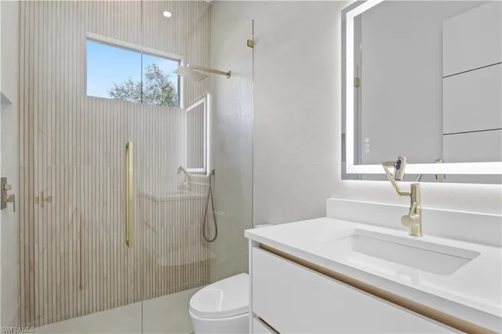 Full bathroom with vanity, tiled shower, and tile walls