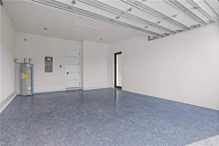 Garage featuring electric panel and electric water heater