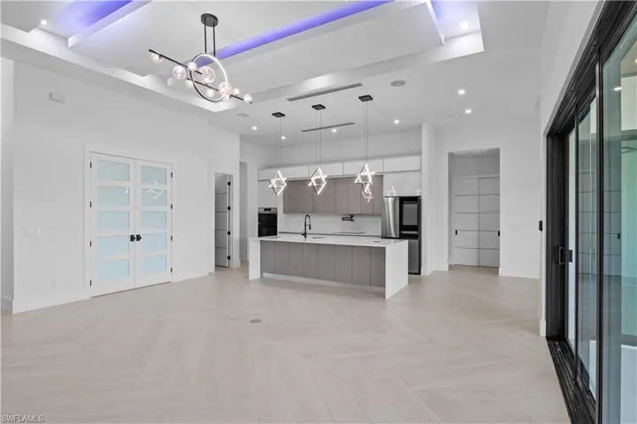 Kitchen featuring modern cabinets, light countertops, recessed lighting, a chandelier, and smart refrigerator