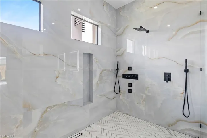Full bath with a marble finish shower