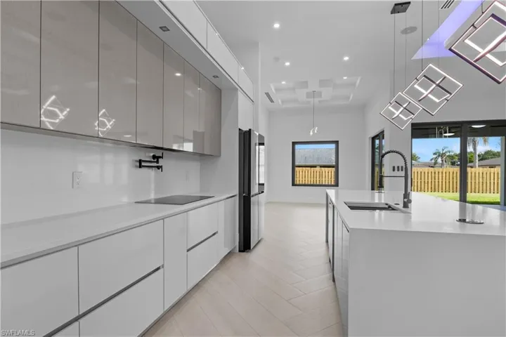 Kitchen featuring modern cabinets, white cabinets, light countertops, recessed lighting, and light wood-style floors