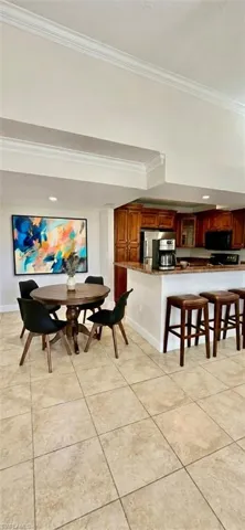 Dining area featuring light tile patterned floors, crown molding, and recessed lighting.Staging