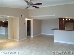Unfurnished living room with ceiling fan and light tile patterned flooring