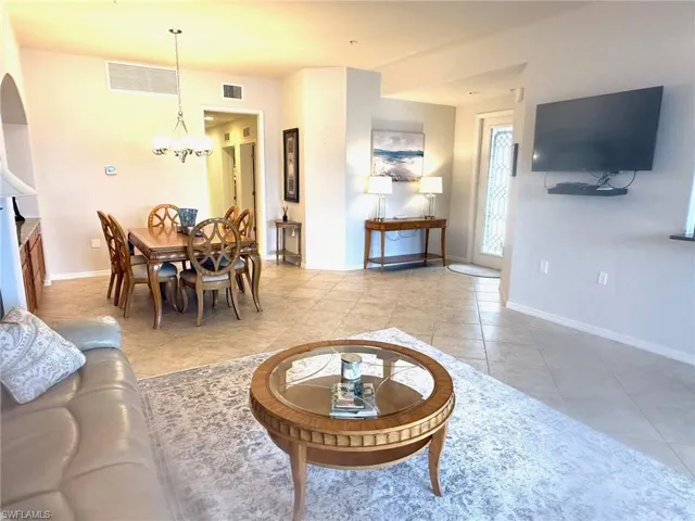 Tiled living room with a notable chandelier