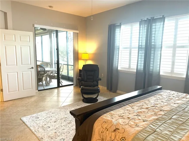 Bedroom featuring light tile patterned flooring and multiple windows