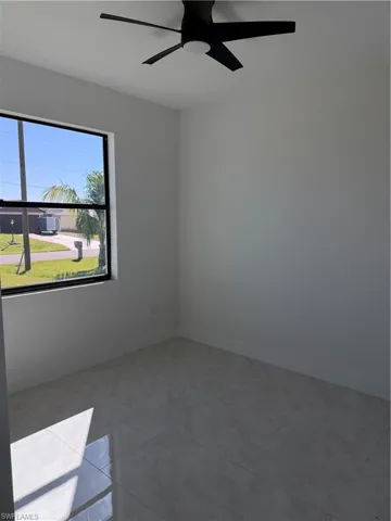 Unfurnished room featuring a ceiling fan and baseboards