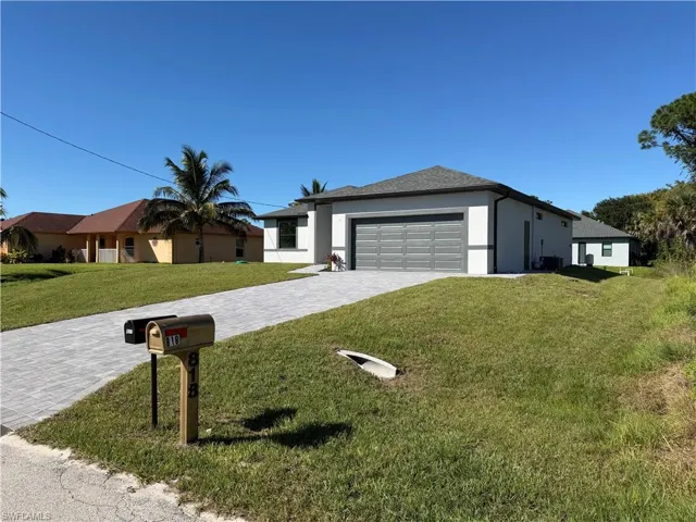 Single story home featuring decorative driveway, a front yard, stucco siding, and a garage