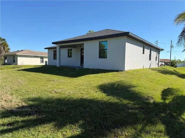 Back of property with a yard, stucco siding, and a patio
