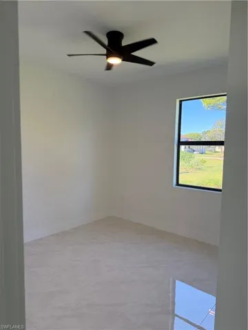 Empty room featuring baseboards and ceiling fan