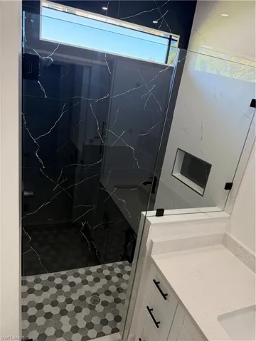Full bathroom with vanity and a marble finish shower