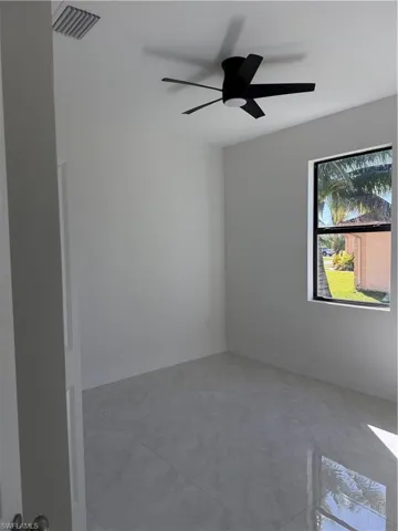 Unfurnished room with a ceiling fan and baseboards