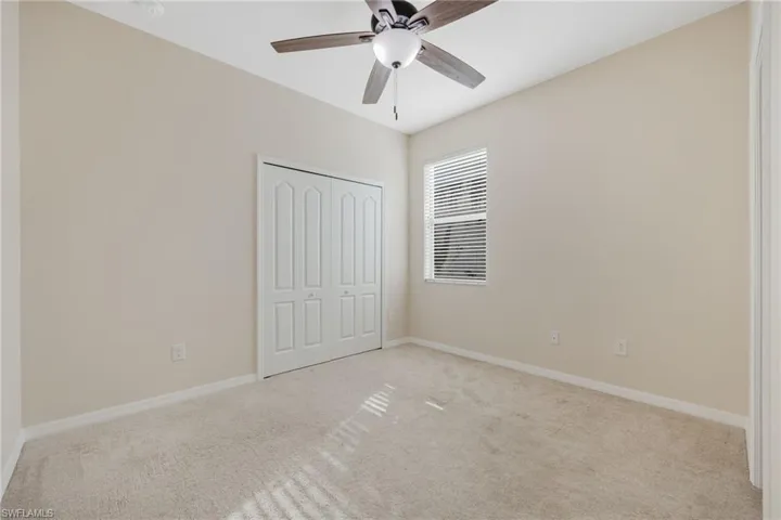 Unfurnished bedroom featuring light carpet, a closet, and ceiling fan