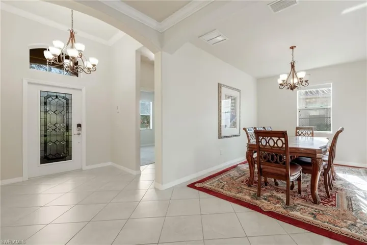 Tiled dining area with a notable chandelier and ornamental molding