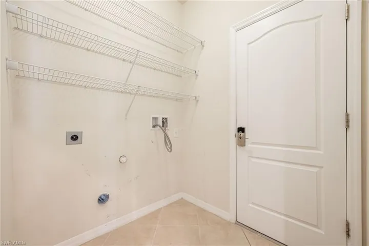 Laundry area featuring hookup for a gas dryer, washer hookup, hookup for an electric dryer, and light tile patterned floors