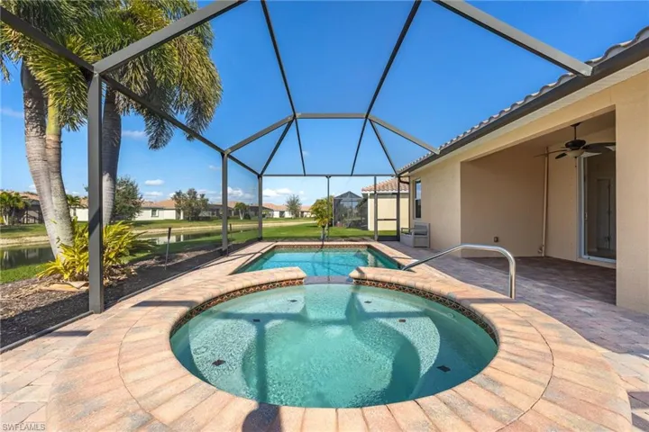View of pool with an in ground hot tub, a lanai, ceiling fan, and a patio