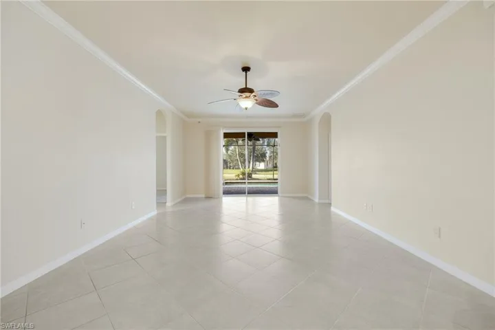 Spare room featuring ceiling fan, ornamental molding, and light tile patterned floors