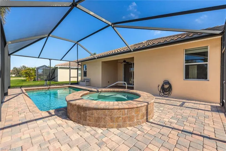View of swimming pool with an in ground hot tub, a lanai, ceiling fan, and a patio area