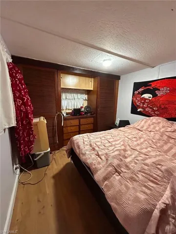 Bedroom featuring hardwood / wood-style flooring and a textured ceiling